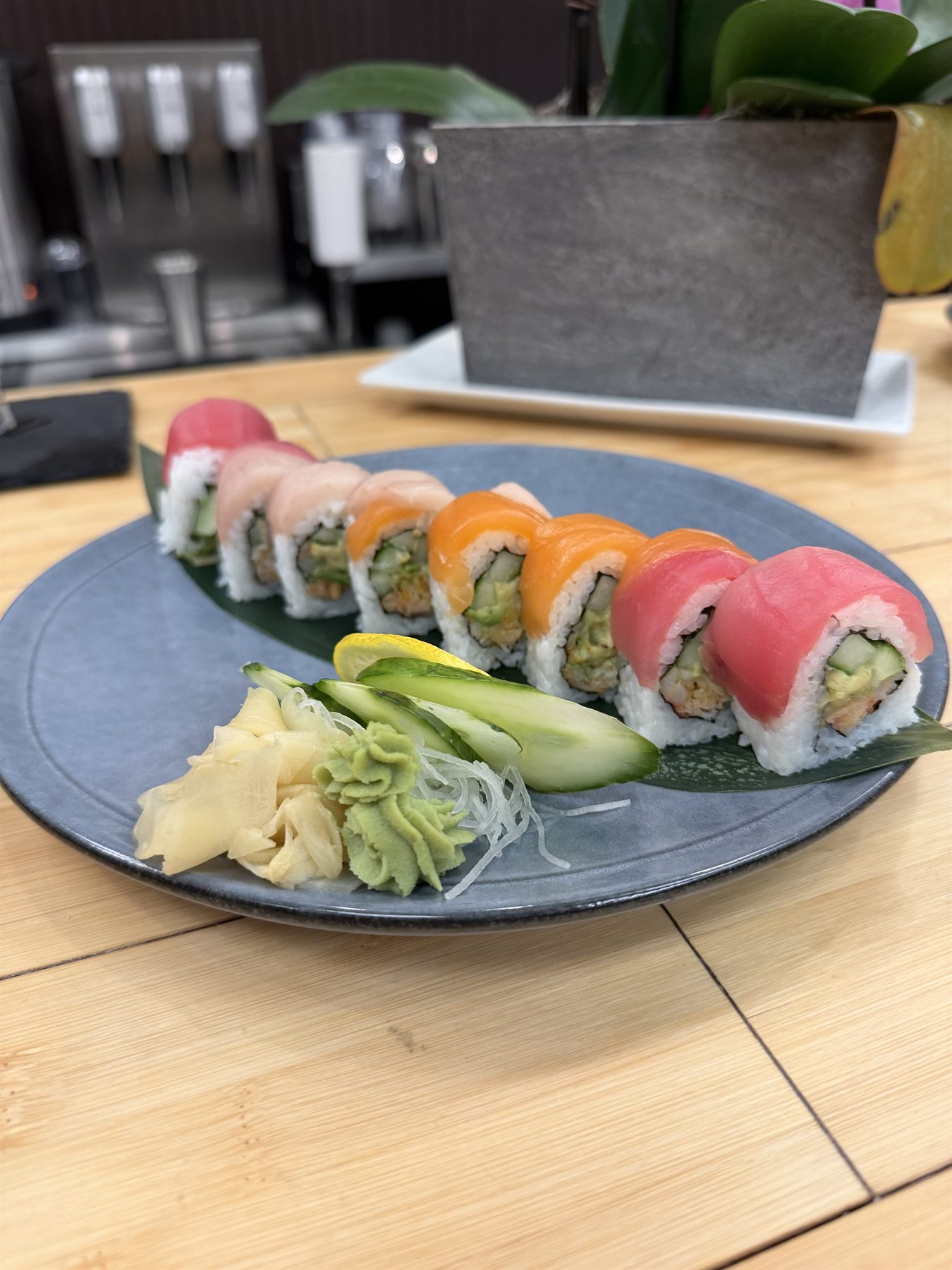Rainbow sushi roll with tuna, salmon and avocado, served with wasabi and pickled ginger